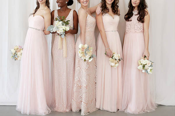 man watching a band on the stage wearing a red t-shirt and black hat.